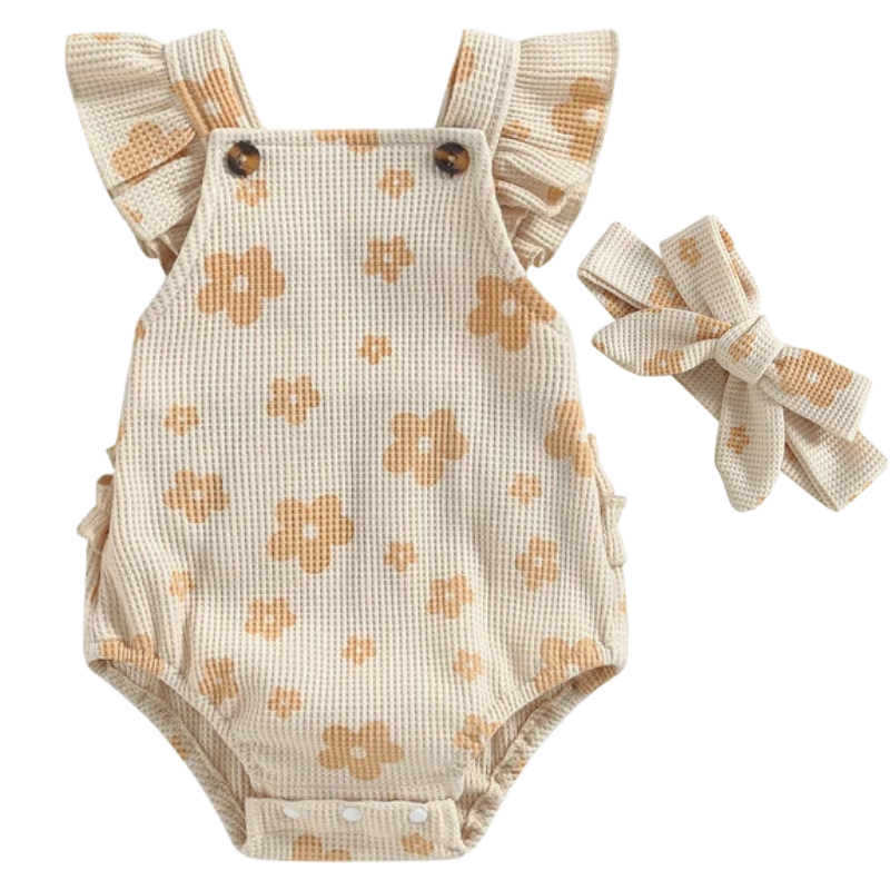 This image shows a Little Eedie romper in a beige cooour with flutter sleeves. It also contains a matching headband