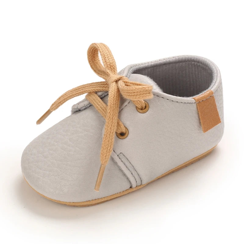 Side view of grey baby walking shoes with laces