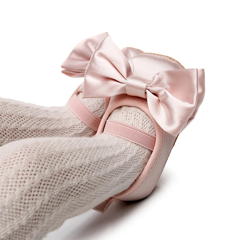 Pink satin baby shoes with large bow and elastic strap





